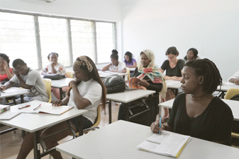 Etudiants en face d'un professeur en train de lever la main pour être interrogé