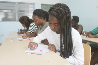 Etudiants en face d'un professeur en train de lever la main pour être interrogé